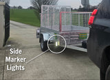 Trailer with side marker lights highlighted on a driveway